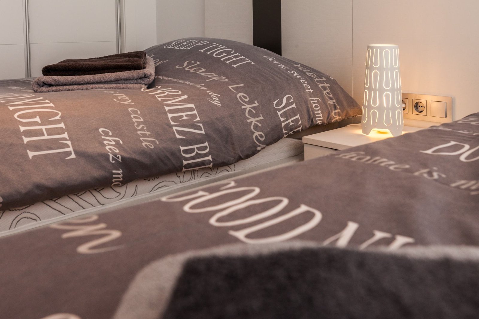Slaapkamer met twee eenpersoonsbedden en handdoeken